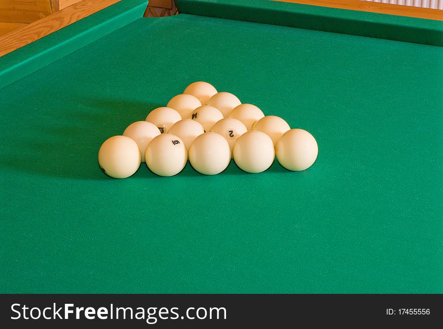 Triangle of balls for Russian billiards on a table with green baize. Triangle of balls for Russian billiards on a table with green baize.