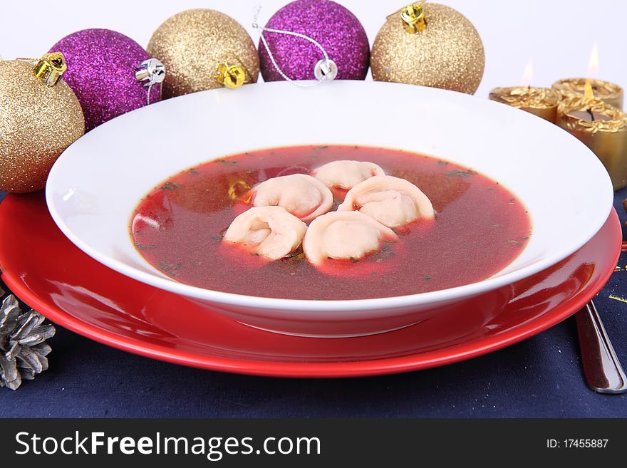 Traditional polish Christmas Eve dish: clear borscht with uszka (a mushroom filled kind of dumplings) and christmas decorations. Traditional polish Christmas Eve dish: clear borscht with uszka (a mushroom filled kind of dumplings) and christmas decorations