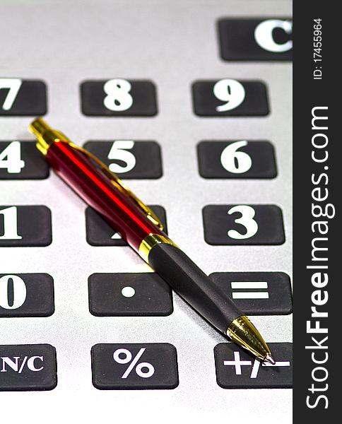 Calculator and pen isolated up close