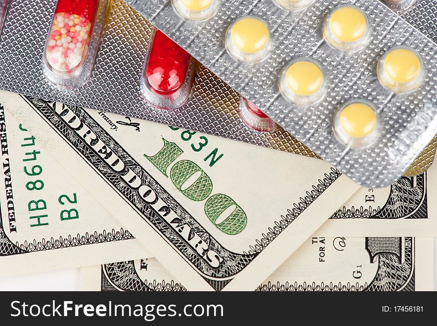 Closeup pills and money, abstract business medical background