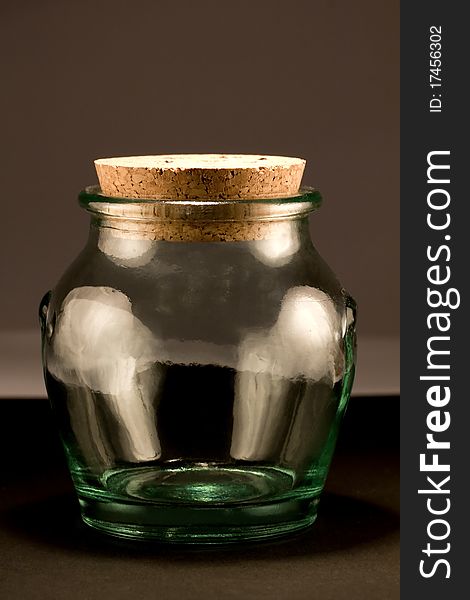 Close view detail of a glass jar isolated on a dark background.