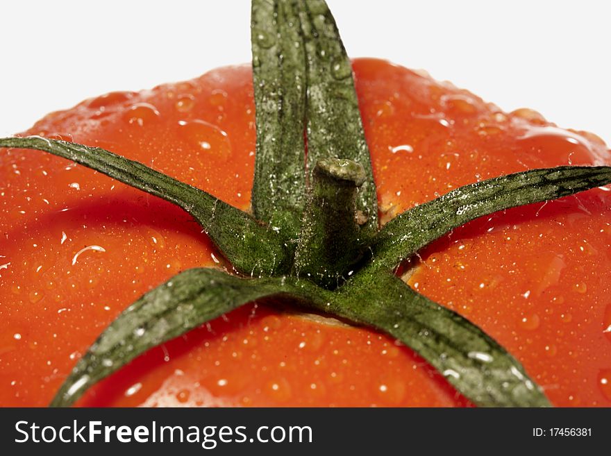 Close view detail of a red tomatoe isolated on a white background.