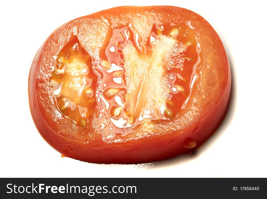 Close view detail of a slice of red tomatoe isolated on a white background.