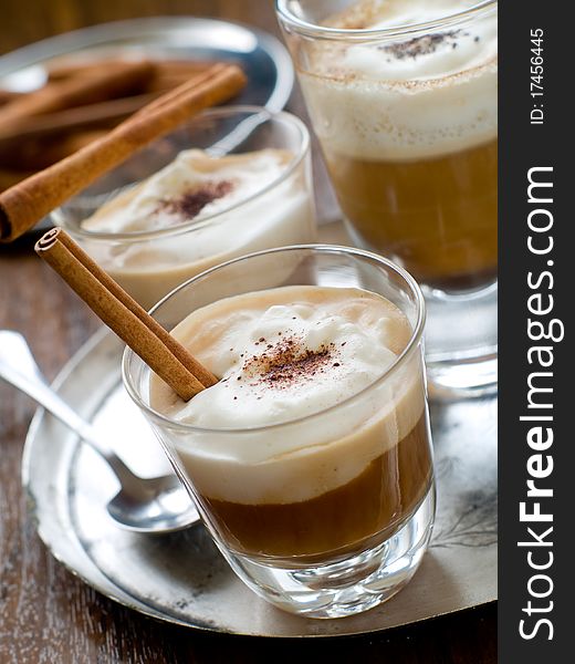 Cafe Latte in glasses with cinnamon stick on plate. Cafe Latte in glasses with cinnamon stick on plate