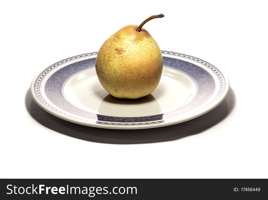 Close view detail of a pear on a plate isolated on a white background.