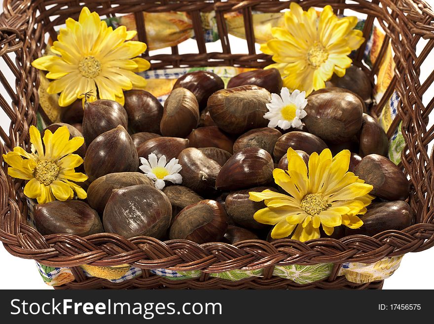 Close view detail of a basket full of chestnuts isolated on a white background. Close view detail of a basket full of chestnuts isolated on a white background.