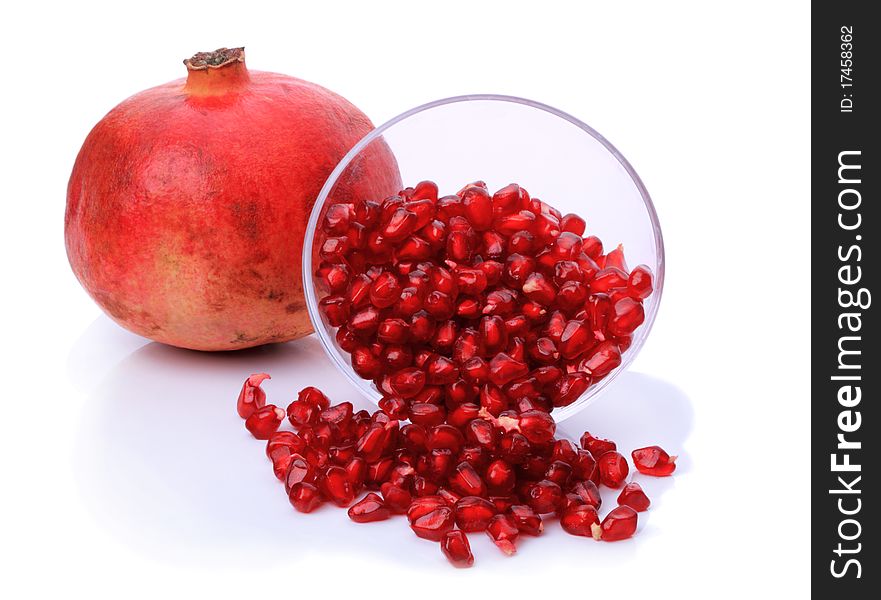 Pomegranate and grain ripe in the bowl isolated on white background. Pomegranate and grain ripe in the bowl isolated on white background