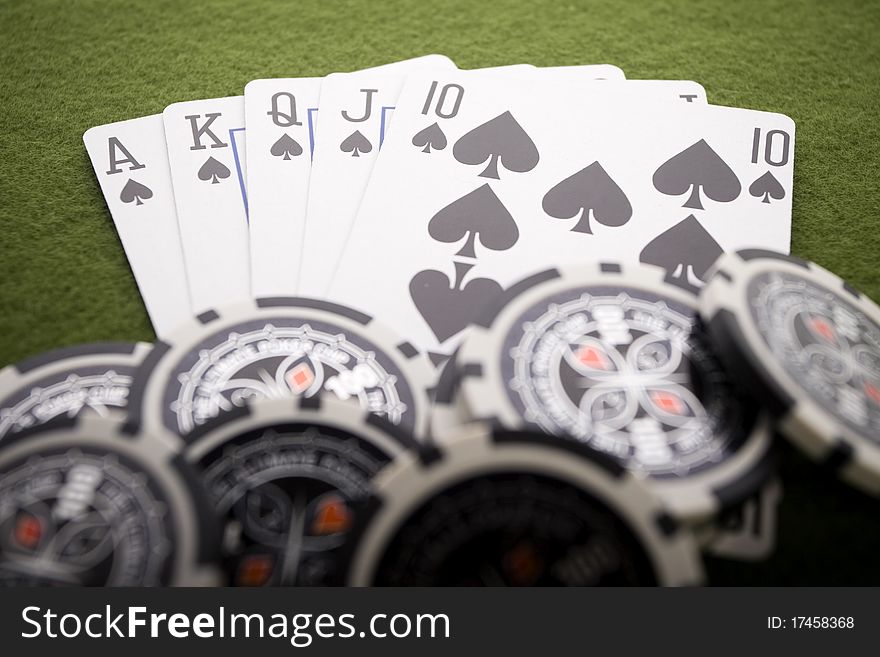 Close-up of Poker cards and gambling chips on green background