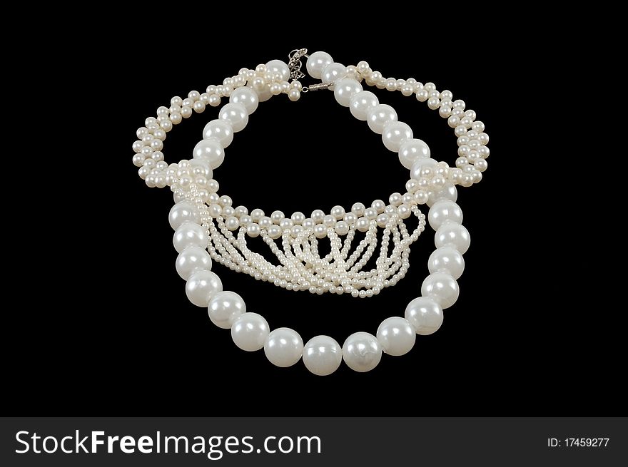 White pearl necklace on a black background
