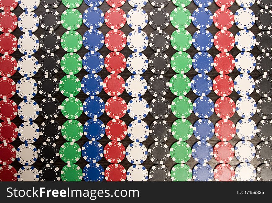 Multi - colored gambling chips on a background. Multi - colored gambling chips on a background
