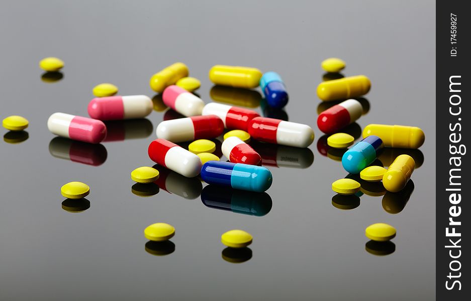 Colorful pills over dark background