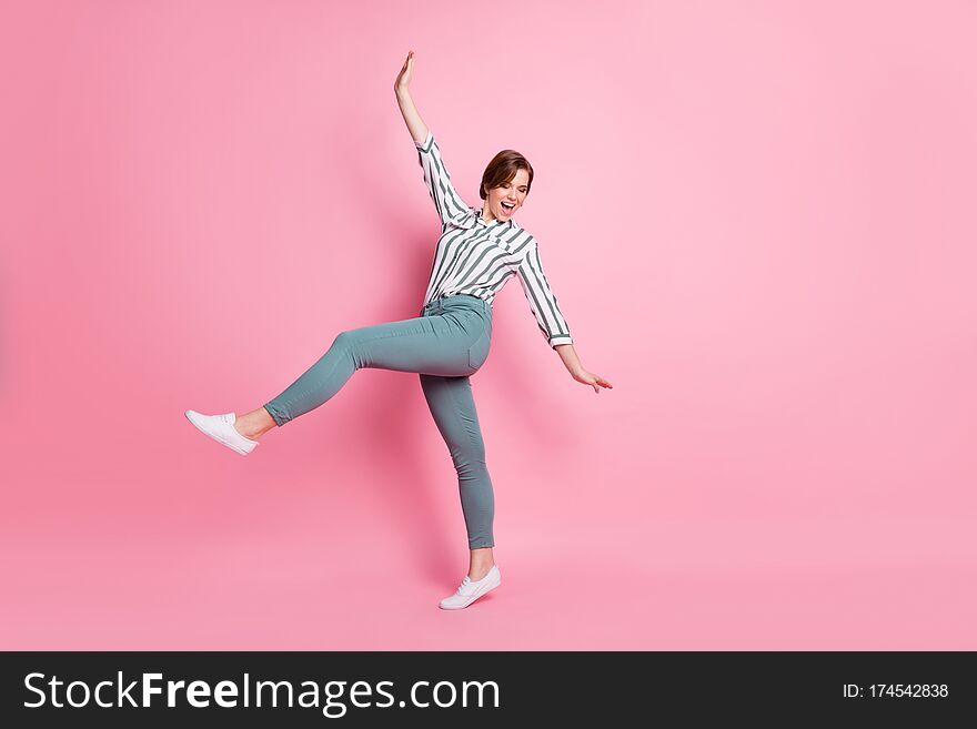 Full size photo of positive content youngster girl have fun spring weekends, raise hands laugh feel rejoice wear stylish clothing isolated over pink color background. Full size photo of positive content youngster girl have fun spring weekends, raise hands laugh feel rejoice wear stylish clothing isolated over pink color background