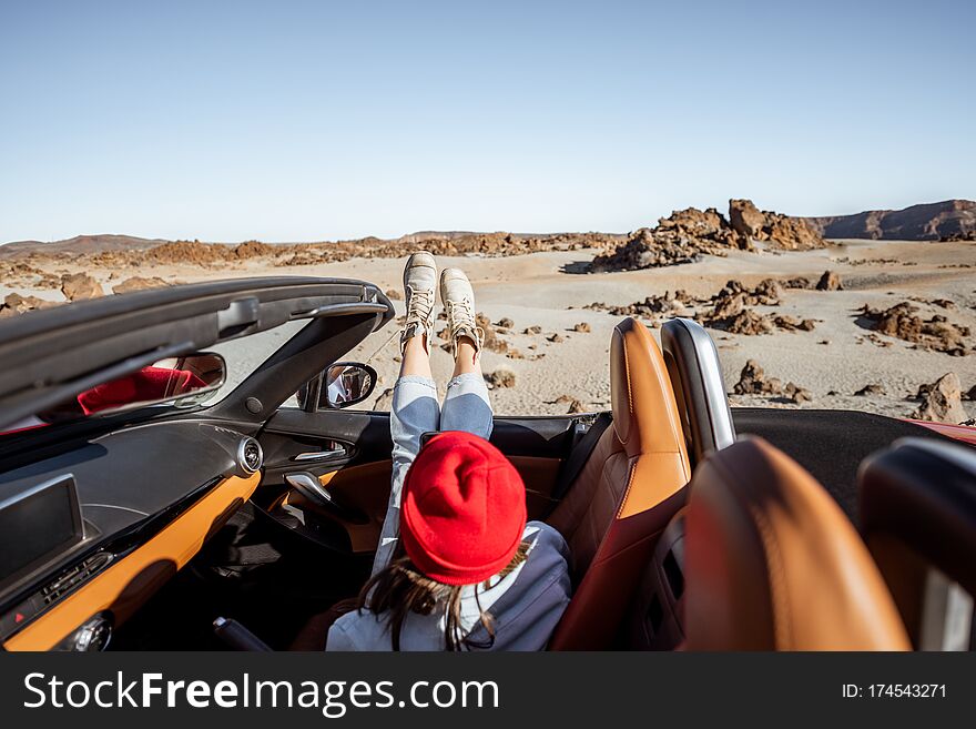 Woman Traveling By Convertible Car On The Desert Valley