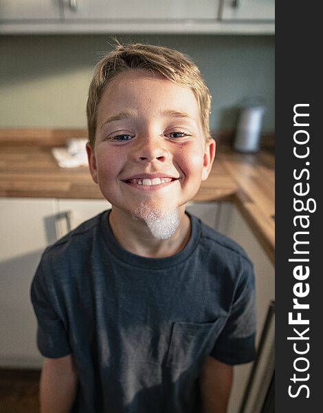 A front view shot of a young boy smiling and looking at the camera, he has bubbles on his face. A front view shot of a young boy smiling and looking at the camera, he has bubbles on his face
