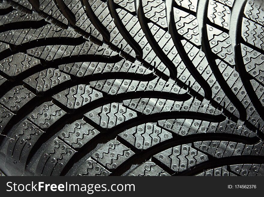 Tyre treads texture, dark abstract background.