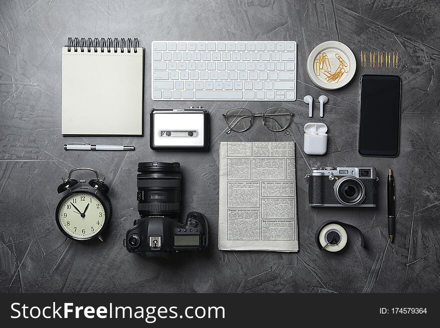 Flat lay composition with equipment for journalist on grey table