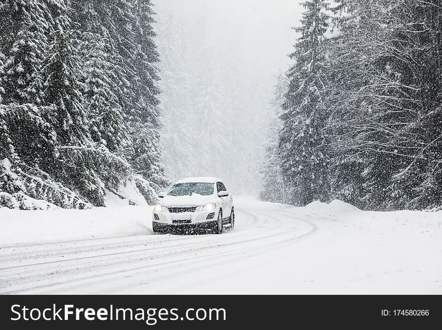 Modern car on snowy road near forest. Winter vacation