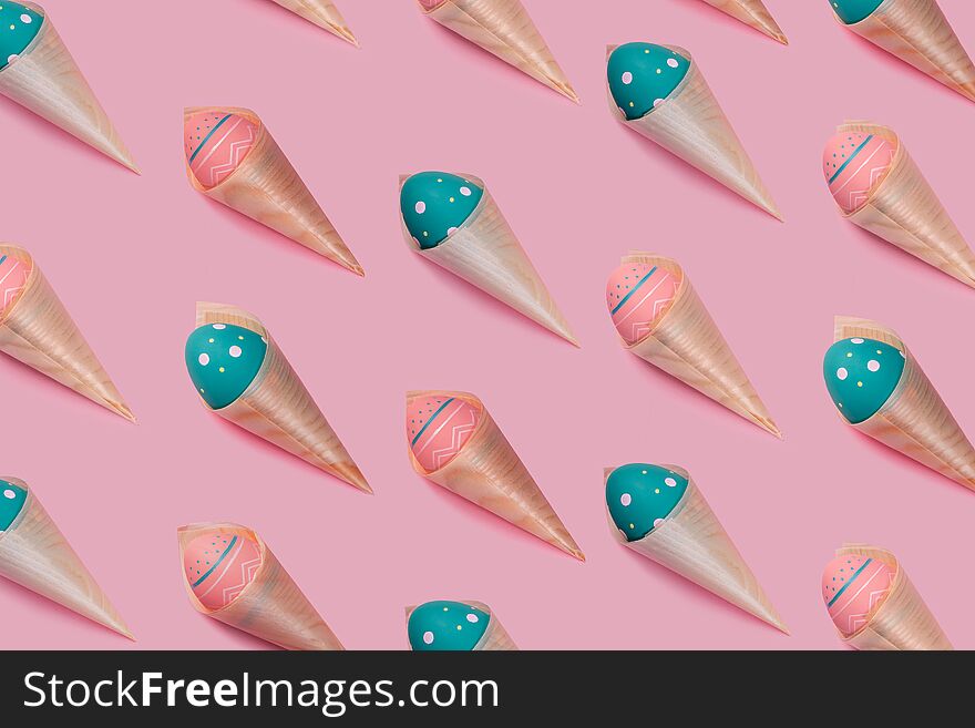 Pattern with colored decorated eggs in bamboo cones looks like ice cream on pink background.