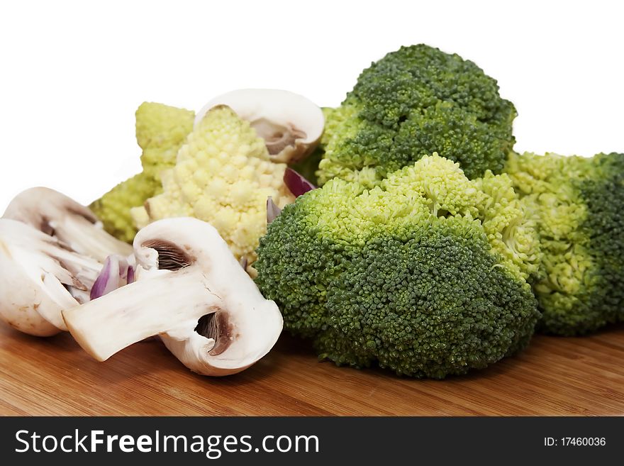 Fresh cauliflower, mushrooms on wooden surface