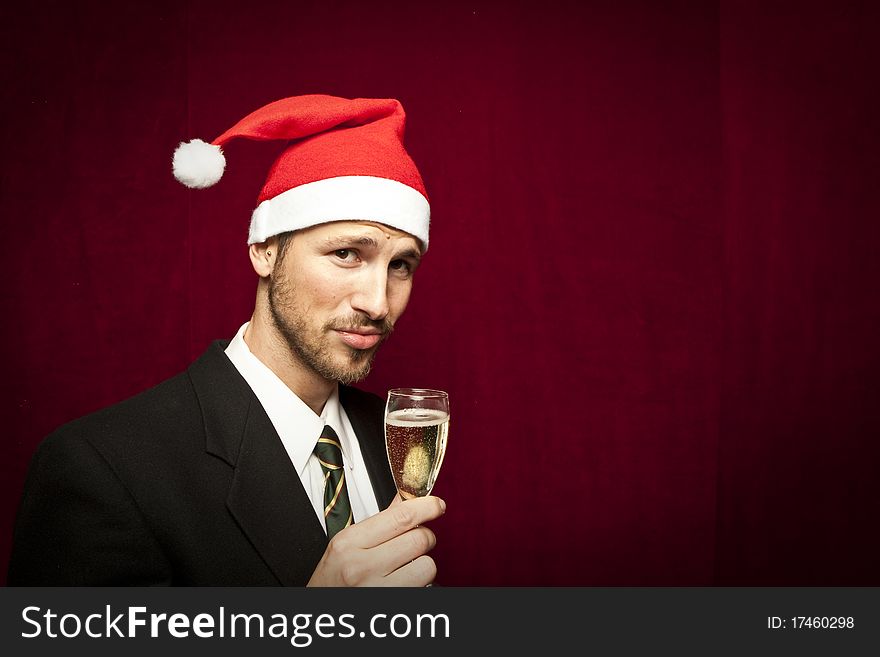 Successful businessman toasting with Champagne with christmas hat