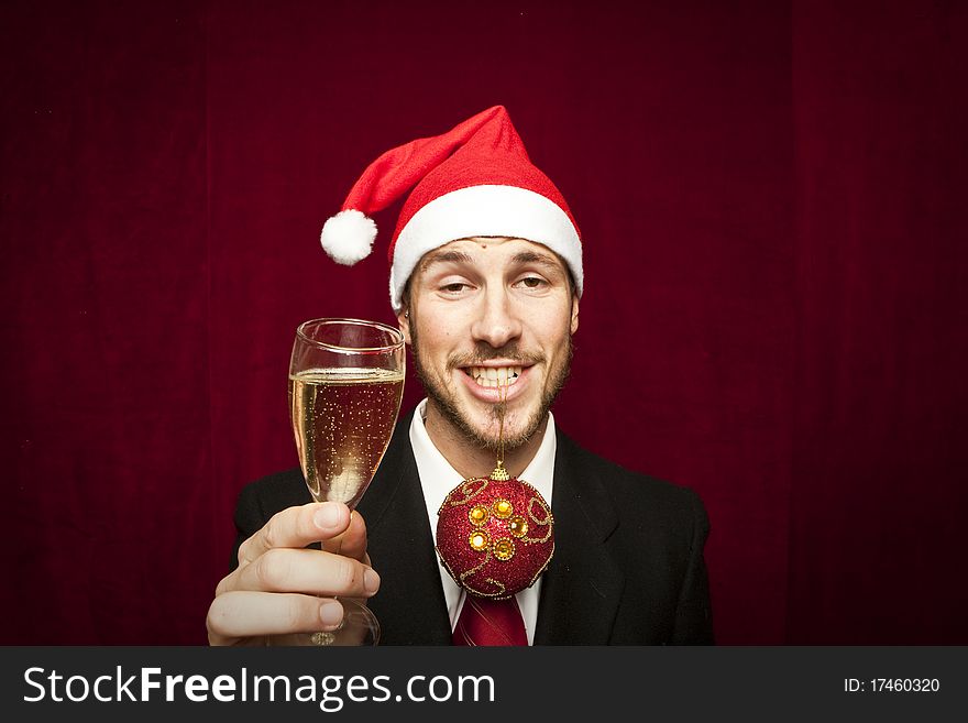 Young funny guy with christmas hat on red velvet background