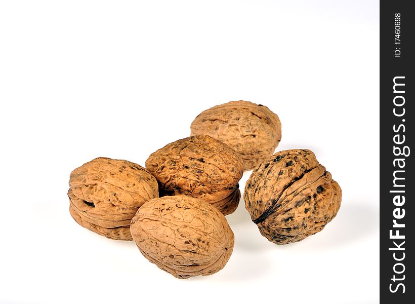 Five walnuts on white background