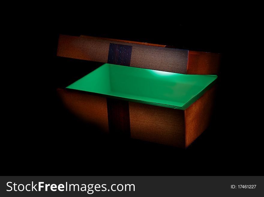 A brown box half opened to reveal a glowing green magic. A brown box half opened to reveal a glowing green magic.