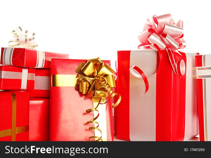 A lot of Christmas presents different values in the red packages with colorful bows. Isolated white background. A lot of Christmas presents different values in the red packages with colorful bows. Isolated white background