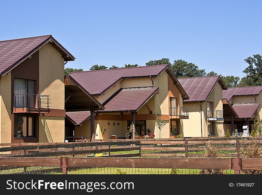 Brown houses with purple rooftops in residential area. Brown houses with purple rooftops in residential area.