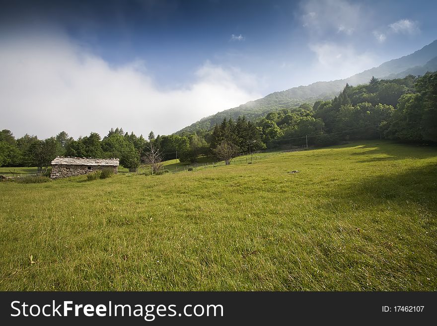 A house made of stone in a green meadow. A house made of stone in a green meadow