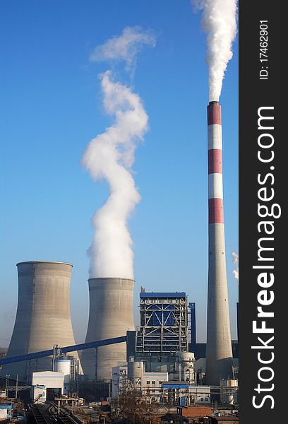 Scenery of water towers and chimney with steam in a heat power plant