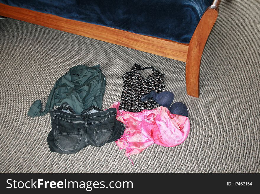 Mens and womens clothes beside bed. Mens and womens clothes beside bed