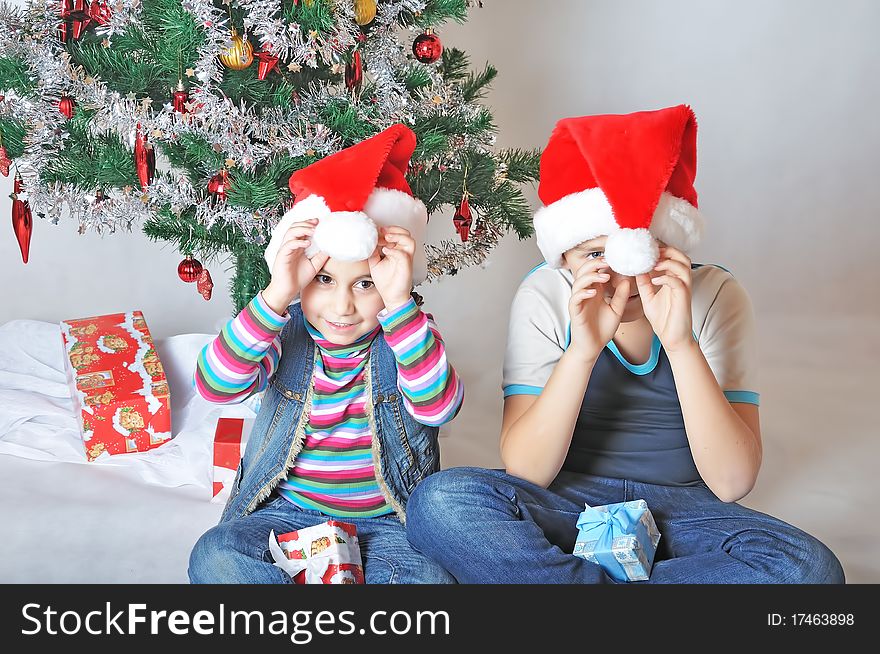 Foolish kids are playing with santa hats. Foolish kids are playing with santa hats