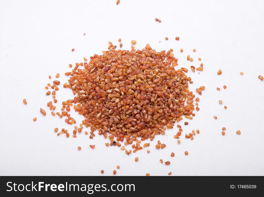 Close up shot of a small pile of buckwheat isolated on a white background.