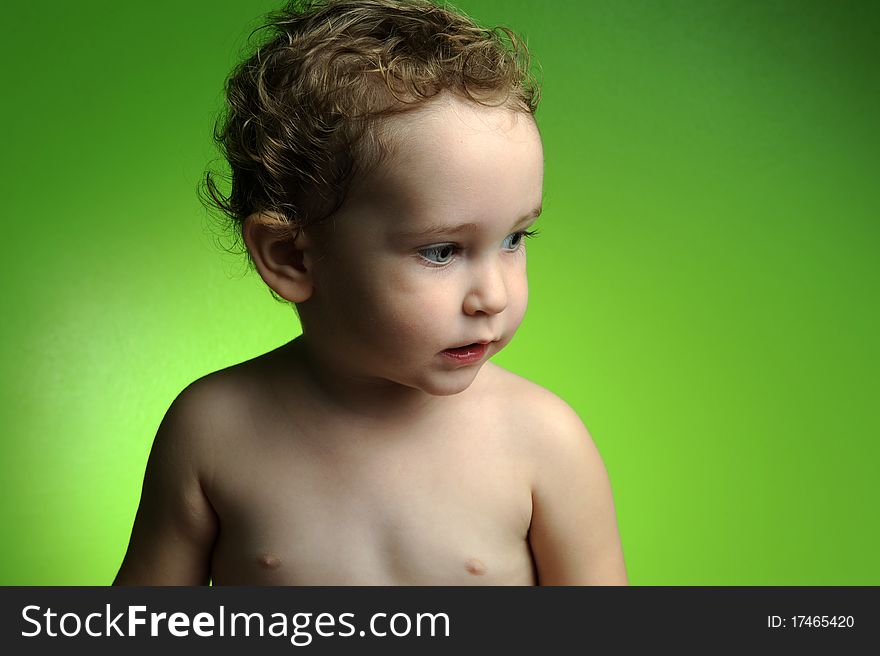 Close up portrait of cute little boy on green background