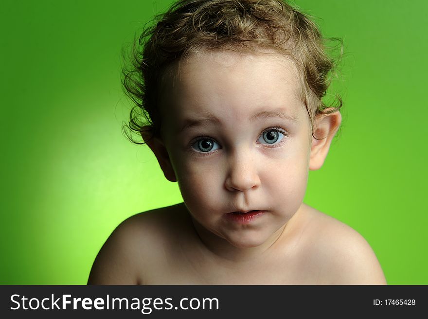 Close up portrait of cute little boy on green background