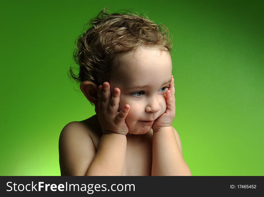 Close up portrait of cute little boy on green background
