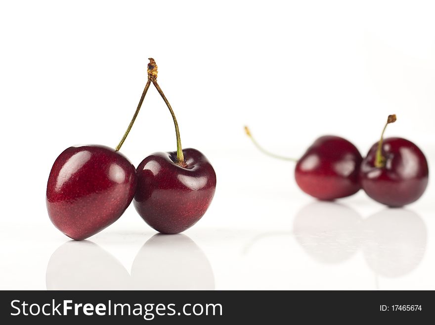 Four red cherries isolated against a white background. Four red cherries isolated against a white background