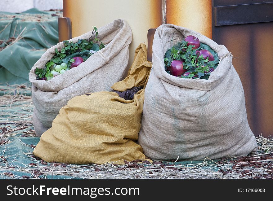 Bags with fruit and ivy on straw. Bags with fruit and ivy on straw