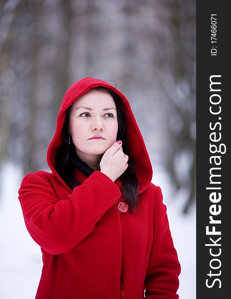 Thoughtful pretty girl in the red coat in winter