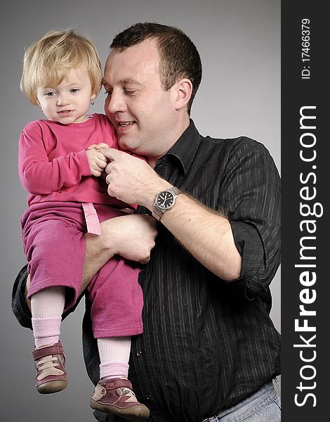 White man posing with his daughter in studio. White man posing with his daughter in studio