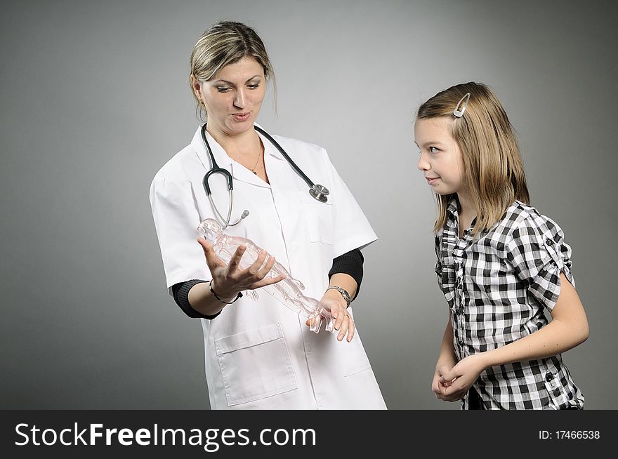 Girl listening and doctor presenting human body structure. Girl listening and doctor presenting human body structure