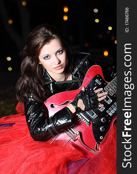 Brunette guitar player girl in the night city