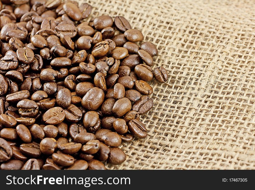 Close up of roasted coffee beans on a burlap sack