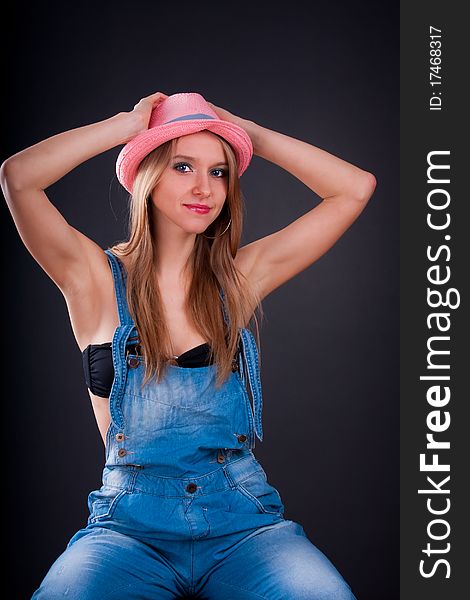 Pretty girl in pink hat and jeans overalls