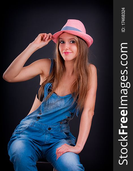 Pretty girl in pink hat and jeans overalls