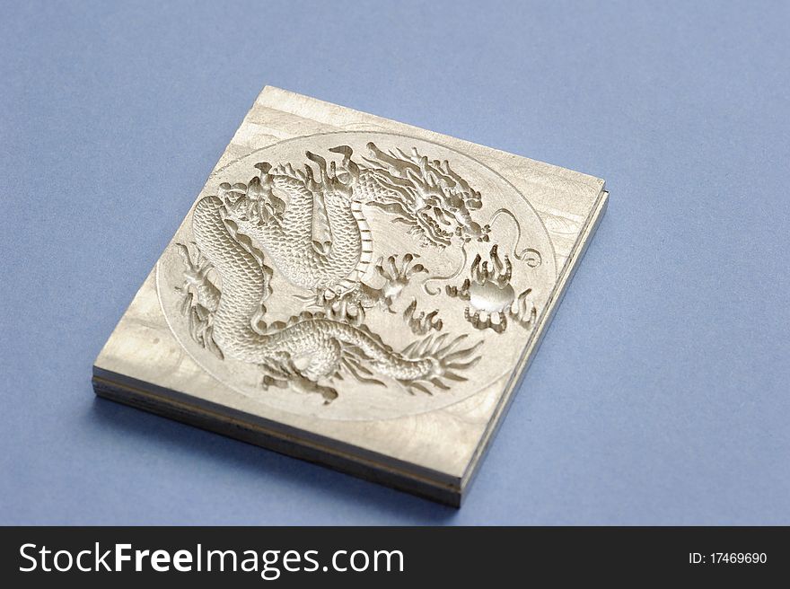 An engraving dragon plate isolated on blue.