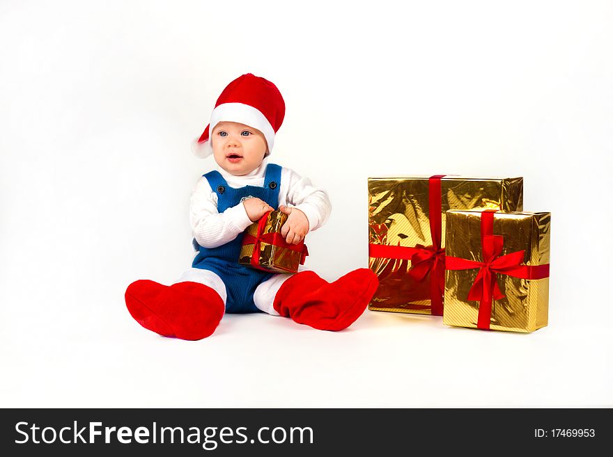 Happy little boy in Santa hat with a bunch of gifts, holiday Christmas, New Year