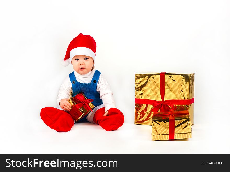 Happy little boy in Santa hat with a bunch of gifts, holiday Christmas, New Year