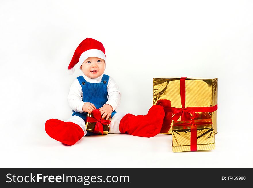Little boy in Santa hat with a bunch of gifts